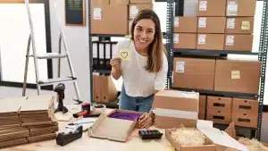 Estratégia de Black Friday 2026: empreendedora sorridente no armazém da sua loja online, rodeada de caixas e encomendas prontas a enviar